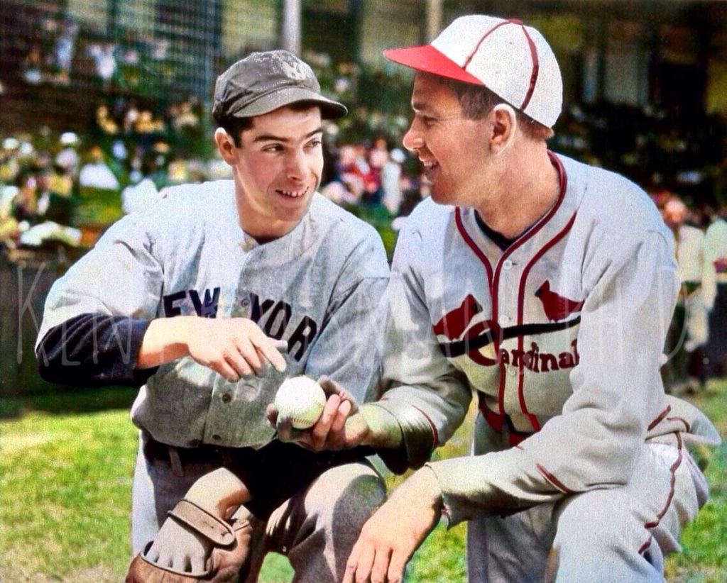 Joe DiMaggio, and dizzy Dean sitting on one knee, holding a Baseball together in their respective uniforms